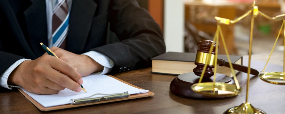 An Albuquerque citizenship lawyer writing and reviewing documents at his desk.
