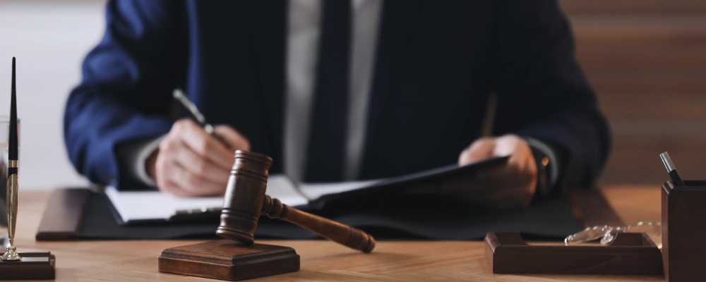 An Albuquerque Immigration Bond Lawyer signing a document behind a hammer and gavel.