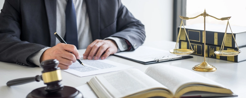 An Albuquerque VAWA immigration lawyer taking notes with an open book on the table.