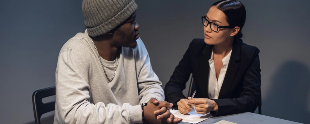 A Dallas U Visa lawyer speaks with her client in a private room, explaining U Visa options and the application timeline.
