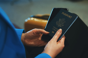 An immigrant at an airport holding on to her passports while waiting for her plane to arrive.