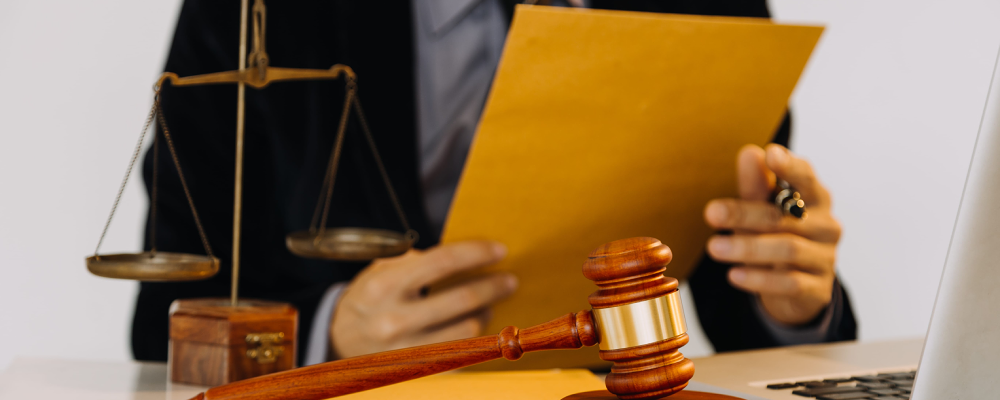 An immigration lawyer seated in an office and holding up an envelope containing a client's immigration documents.