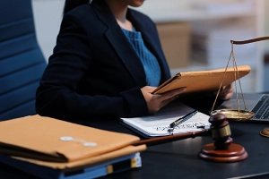 An immigration lawyer holding an envelope with both hands and sitting at an office desk